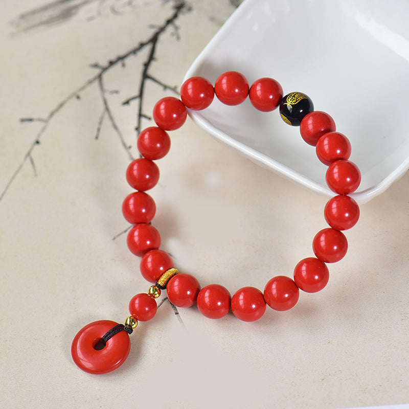 Armband aus Kunstharz in Zinnoberrot mit Obsidian- und Scheibenanhänger 